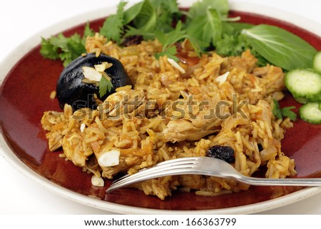 An authentic Saudi chicken kabsa (known in Qatar as majbous), garnished with raisins, parsley and almond flakes, on a serving bowl. Kabsa is a national staple for Saudi Arabia and the Arab Gulf States
