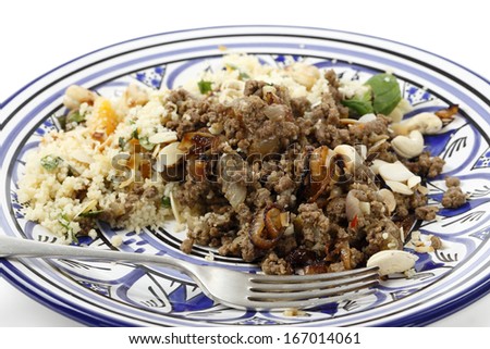 Minced beef cooked with onion and spices, served with couscous and garnished with toasted nuts and caramelised onion in the North African, Moroccan, style