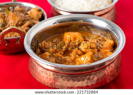 Indo-Chinese chili garlic chicken, a North Indian fusion food from Kolkata, with rice and Malabar chicken behind