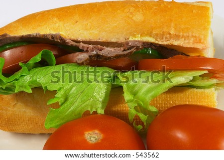 A beef salad sandwich, with tomato, cucumber and iceberg lettuce.