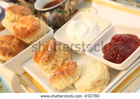 A traditional British cream tea, with scones (biscuits), strawberry jam, cream and tea.