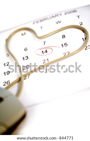 Mouse cord heart on a calendar marked for Valentine\'s Day - don\'t forget to e-message her on February 14! Shallow depth of field, focus on the special date.