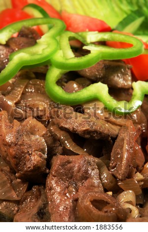 Liver and onions, close-up, with a salad.