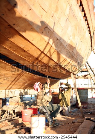 Craftsmen repair a wooden dhow in Doha, Qatar.