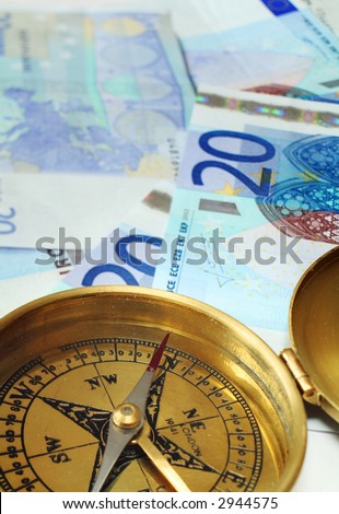 A compass, its needle indicating north, on a pile of 20 euro notes, symbolising a good investment decision or some financial success.