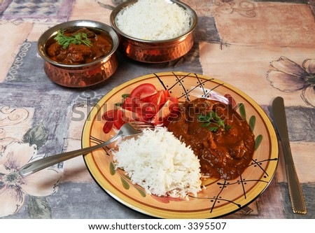 A meal of Madras butter beef curry, served with basmati rice and sliced tomato.