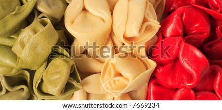 Coloured tortellini pasta shells arranged in the form of an Italian flag.