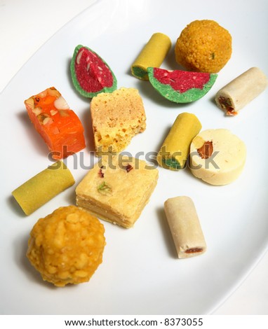 Indian (subcontinent) sweets laid out on a plate. Sweets are shared at all manner of celebrations within the Indian community.