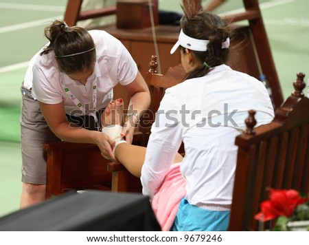 Serbia's Ana Ivanovic has her ankle bandaged after falling on court in the final game of her Qatar Total Open debut against  Olga Govortsova, February 20, 2008.