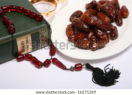 Dates, a coffee cup waiting to be filled, beads, and a copy of the Holy Qur\'an, all are symbolic of the Muslim fasting month of Ramadan and of the breaking of the fast each evening at Iftar.