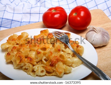 Pasta with a cheese sauce poured over it and baked, like macaroni cheese, with a sprig of italian parsley.
