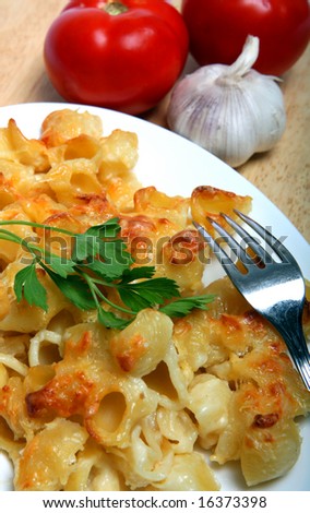 Pasta with a cheese sauce poured over it and baked, like macaroni cheese, with a sprig of italian parsley.