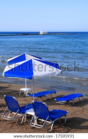 Sunbeds overlooking the fishermen\'s church at the end of Georgioupolis pier, central north Crete, Greece,
