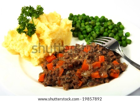 A meal of minced beef (ground beef) onions and carrots with mashed potatoes and peas