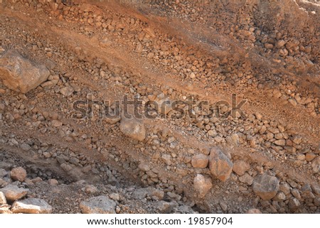 Unconsolidated deposits, apparently caused by flash flooding, in a road cutting beside the gorge east of Paleochora, southern Crete, Greece. The set of repeating units is a couple of feet thick.