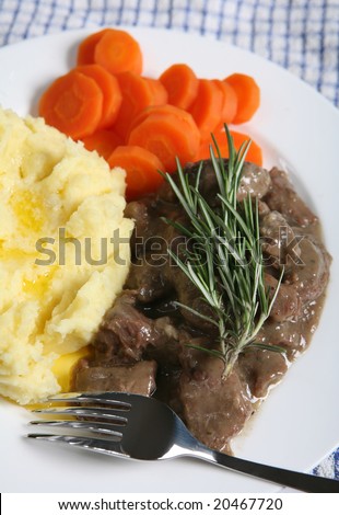A meal of fricasseed lamb (stew in white sauce) with creamed potatoes and carrots, topped with a sprig of rosemary.