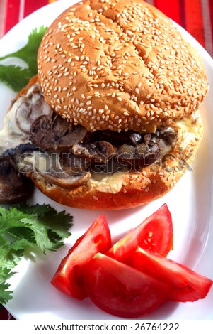 A vegetarian burger made with mushrooms and cheese and garnished with tomato