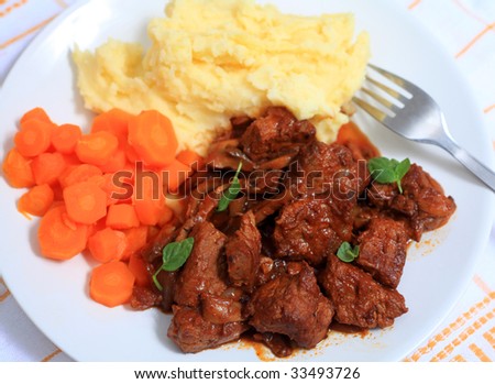 A meal of boeuf bourguignonne french beef stew, viewed from above. This traditional French dish is made with onions, wine, tomato paste, garlic and bacon