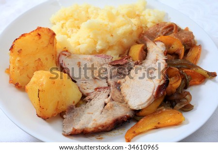 A meal of roast pork, served with roast potatoes and oven-roasted peppers