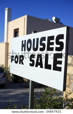 House builder\'s for sale sign with all personal details removed and a modern mediterranean-style villa in the background