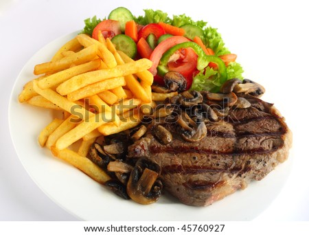 A grilled ribeye steak served with mushrooms,  chips (french fries) and a garden salad of lettuce, cucumber, baby carrot and capsicum