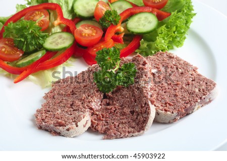 A meal of corned beef with salad on a white plate