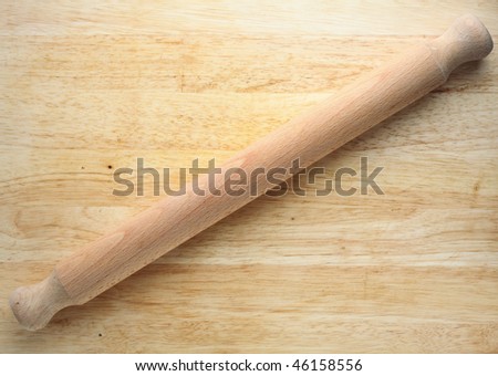 A rolling pin on a wooden board, with loads of room for copy,