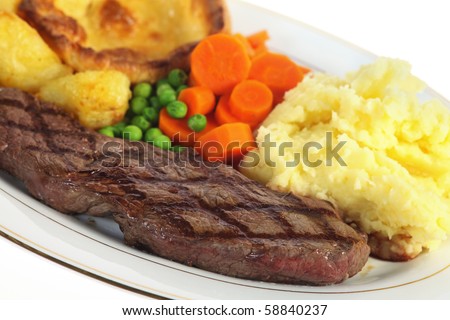 A traditional pub-grub style British meal of rump steak, mixed veg, mashed and roasted potatoes and