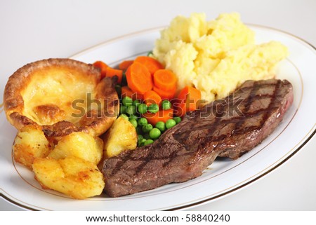 A traditional pub-grub style British meal of rump steak, mixed veg, mashed and roasted potatoes and