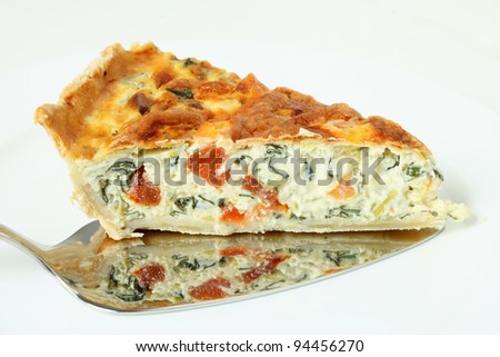 Horizontal view of a piece of delicious quiche made from spinach beet (aka Swiss chard or sea kale beet), leek and tomato baked in a cheesy egg custard