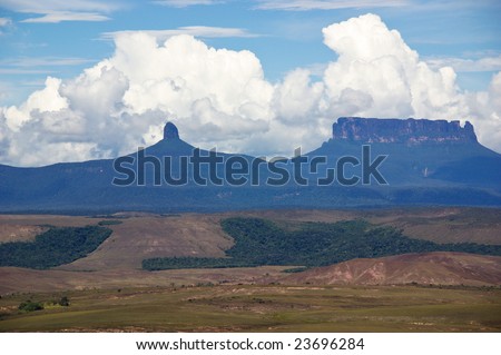 White clouds in blue sky over table-top mountains called Tepui in Gran Sabana, Guayana Highlands, Venezuela, South America. Events of novel of A.Conan-Doyle The Lost World took place here