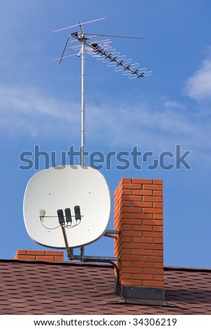 Satellite antenna, TV antenna and chimney on roof