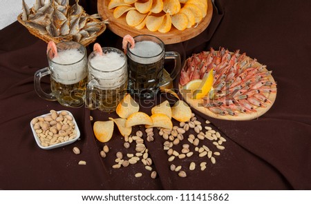 Beer and snacks set: chips, pistachio, shrimp and fish