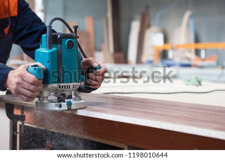 Furniture production or craft concept: worker polishing the wood surface of furniture part with polish machine