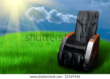 Sunny day with massage arm-chair on the grass field