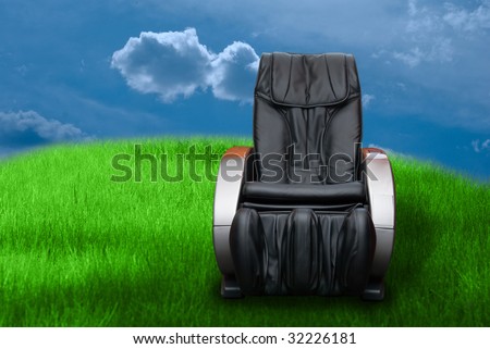 massage arm-chair on the green grass field background.