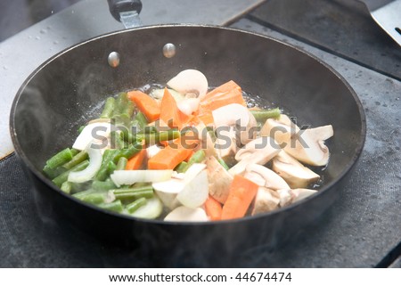 Frying vegetables on the pan with smoking