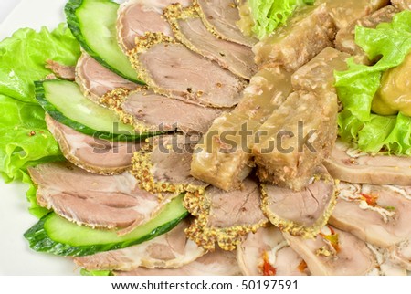 Closeup jellied minced meat and meat cuts on green salad