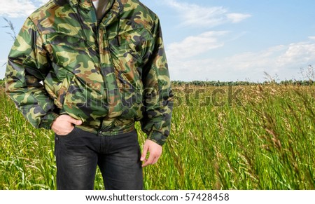 camouflage man closeup at the green meadow