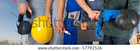 workers closeup with equipment on building background