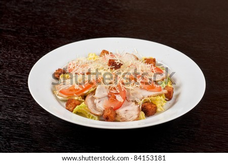 Salad of lettuce, chinese cabbage, tomato, garlic rusk, parmesan cheese, sauce and chicken meat