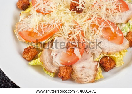 Salad of lettuce, chinese cabbage, tomato, garlic rusk, parmesan cheese, sauce and chicken meat