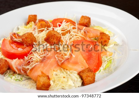 Salad of lettuce, chinese cabbage, tomato, garlic rusk, parmesan cheese, sauce and smoked salmon filet