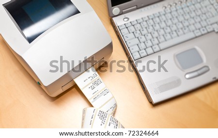 Label and barcode printer next to a notebook