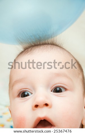 Surprised child, and hair from a static electricity reach for a balloon