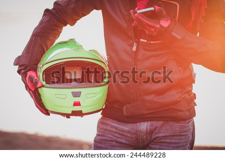 biker man helmet and mobile phone in hand sunset