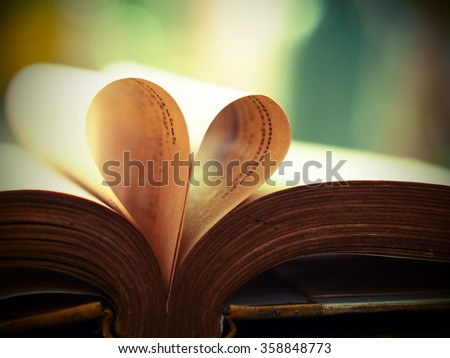 old book page decorate to heart shape for love in valentine day with blurred background and vintage color tone style. book lover. heart love from book page, composition of book, page book
