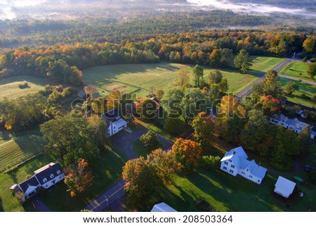 An aerial view of a hot air balloon floating over the Vermont country side