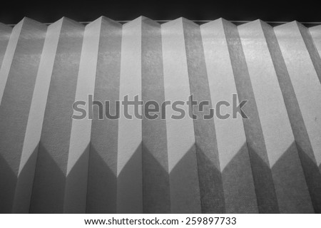 shadow in the shape of triangles from paper blinds on the wall, streaks of light and shadow, abstract background