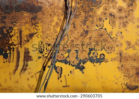 old rusty metal wire on a background of rusty metal surface painted with yellow paint, texture, background